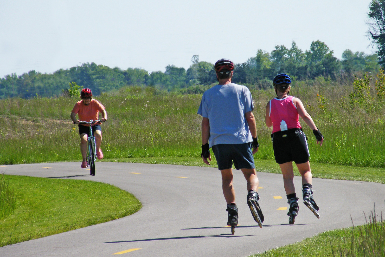 Roller-bladers and a cyclist about to pass each other on the Blacklick Creek Greenway Trail in the north west part of Pickerington Ponds.