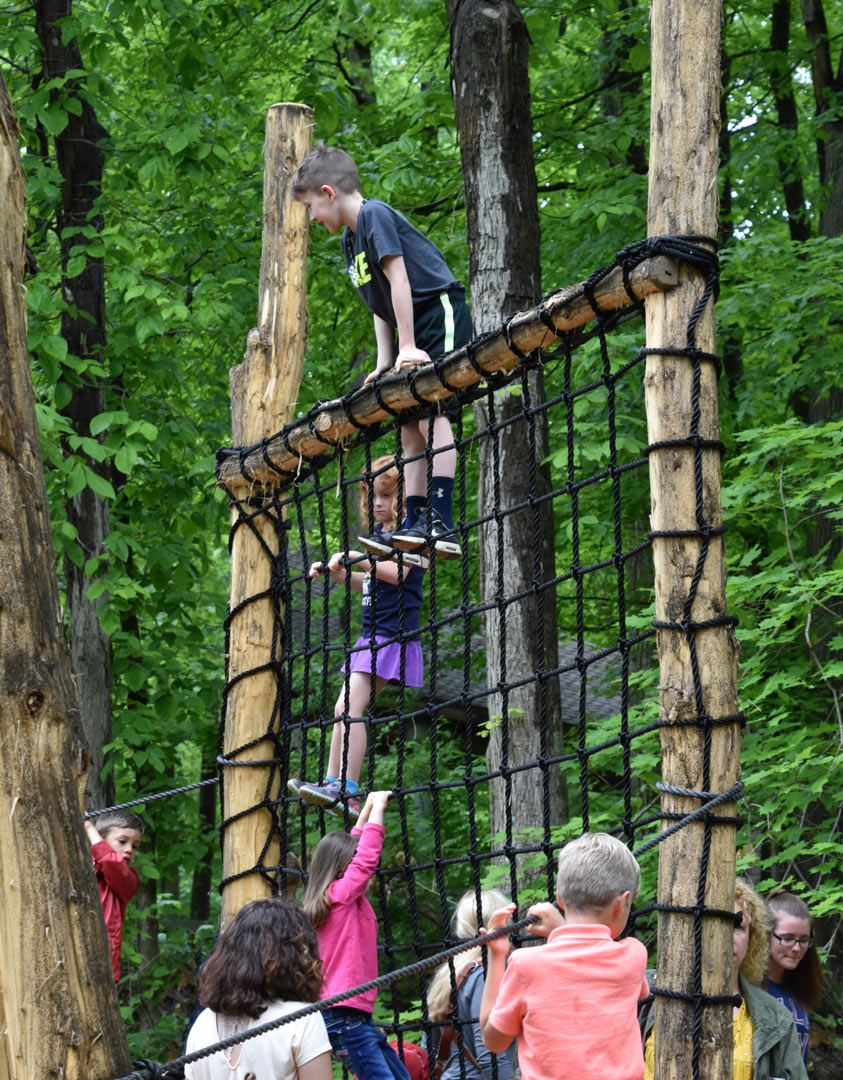 Kids play on the cargo net in the natural play area at Blendon Woods