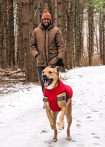 Man and dog walk on Sweetgum Trail at Walnut Woods Metro Park